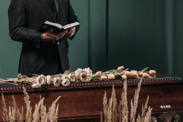 Funeral celebrant reading behind casket