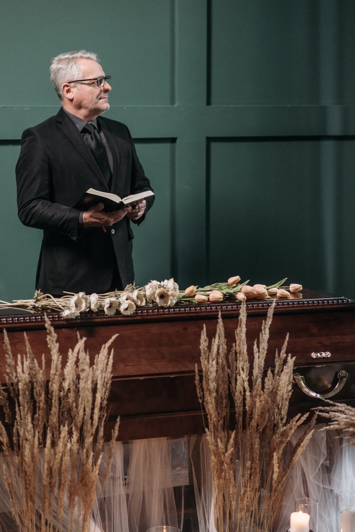 Funeral celebrant reading behind casket